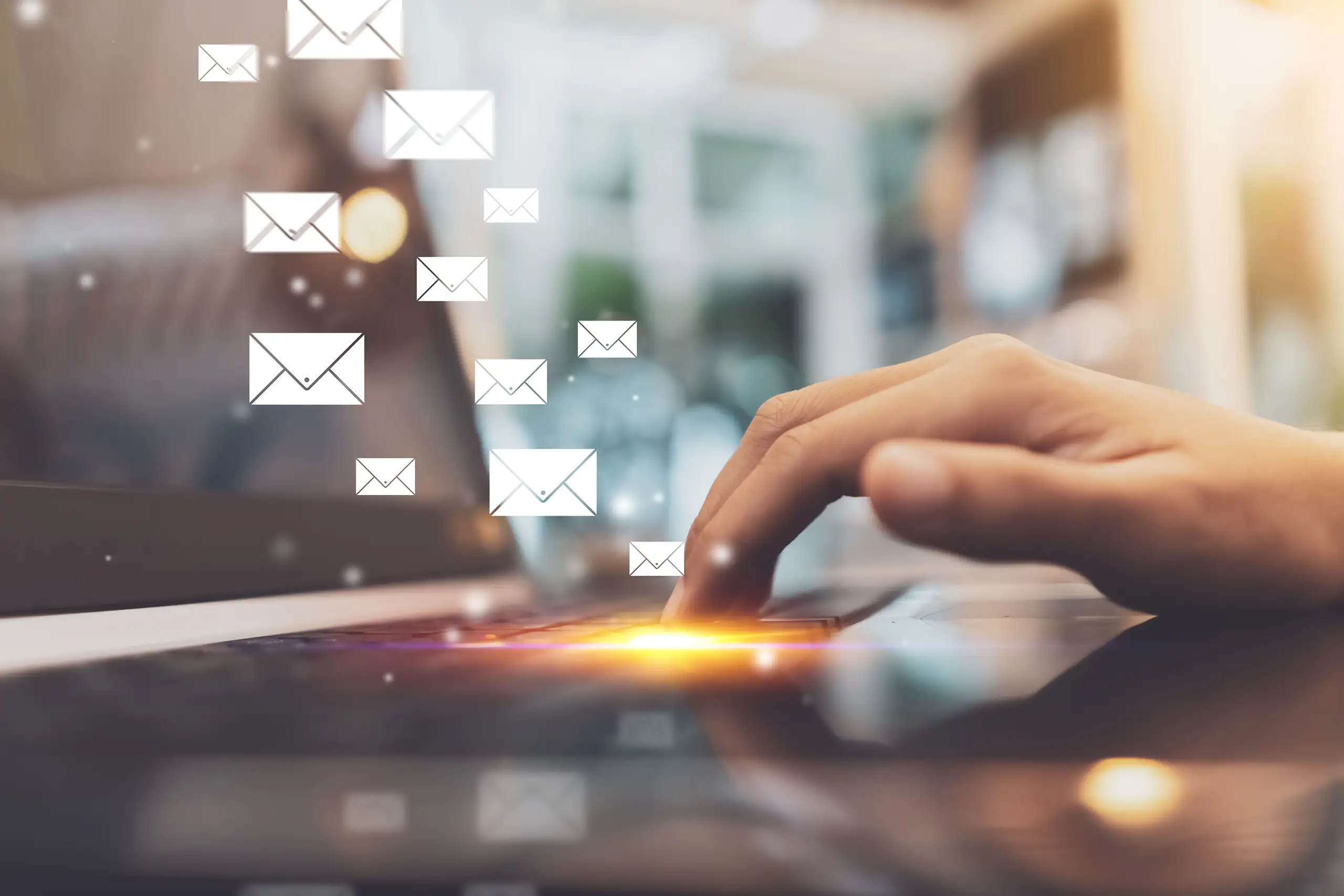 Elevation Learning - newsletters - closeup of hand on keyboard with envelope icons overlaid